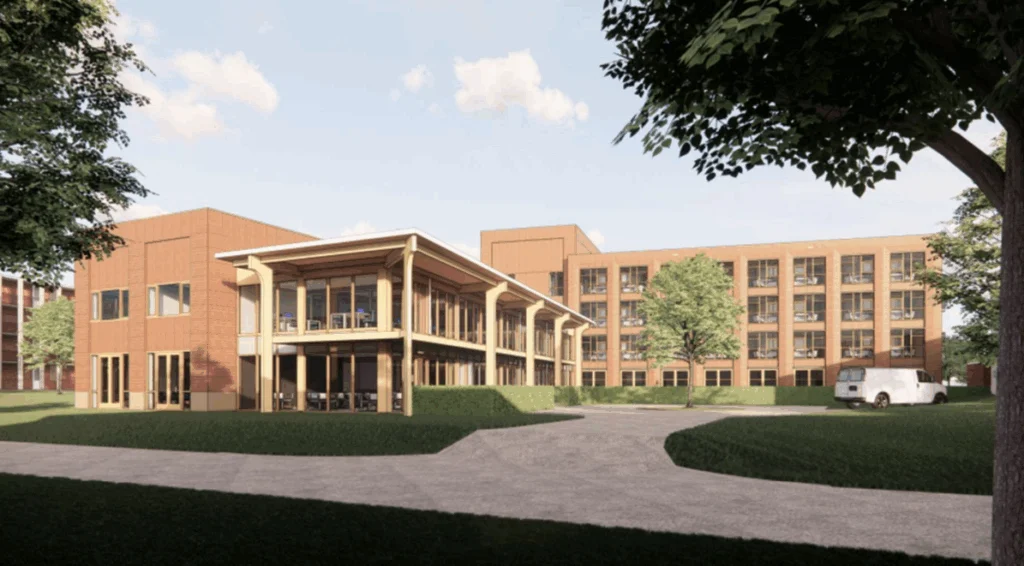 Modern gebouw met rode bakstenen, houtaccenten, glazen patio en groene omgeving met bestelwagen